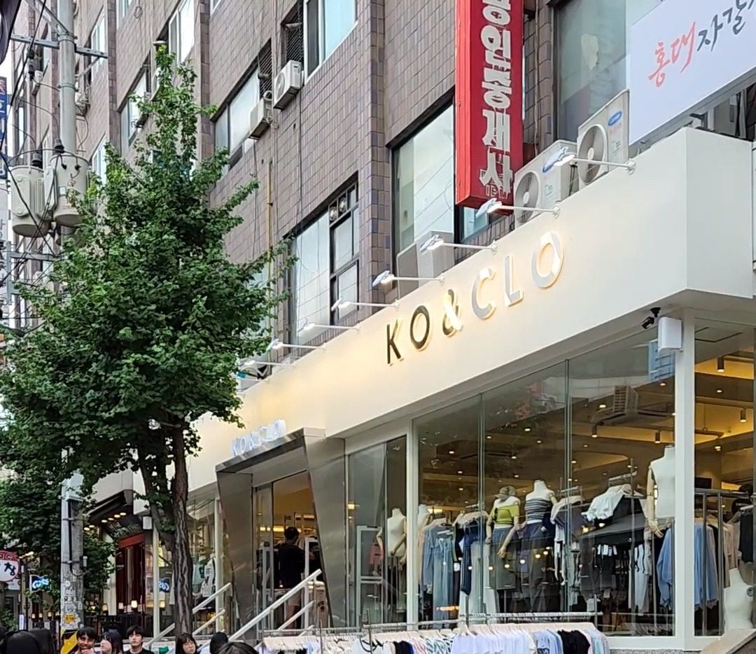 KO&CLO Hongdae — a white storefront with gold lettering and full-height glass